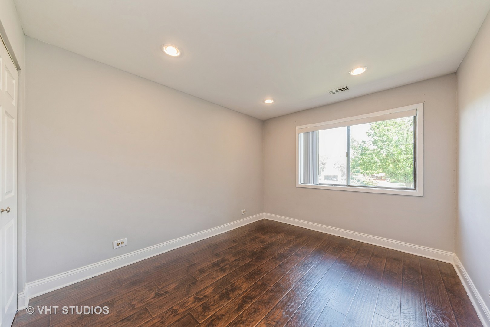 1400 North Elmhurst Road, Unit 219 Mount Prospect, IL 60056 - Photo 8 of 10 an empty room with wooden floor and windows