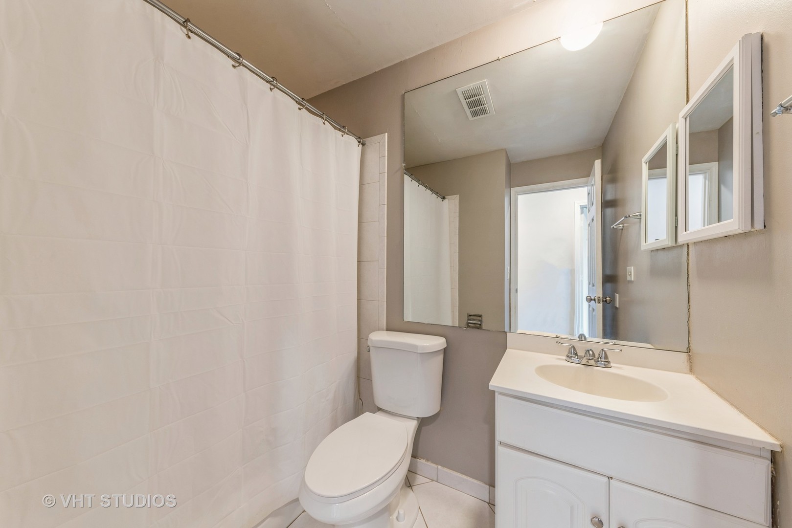 1400 North Elmhurst Road, Unit 219 Mount Prospect, IL 60056 - Photo 9 of 10 a bathroom with a toilet a sink and a mirror