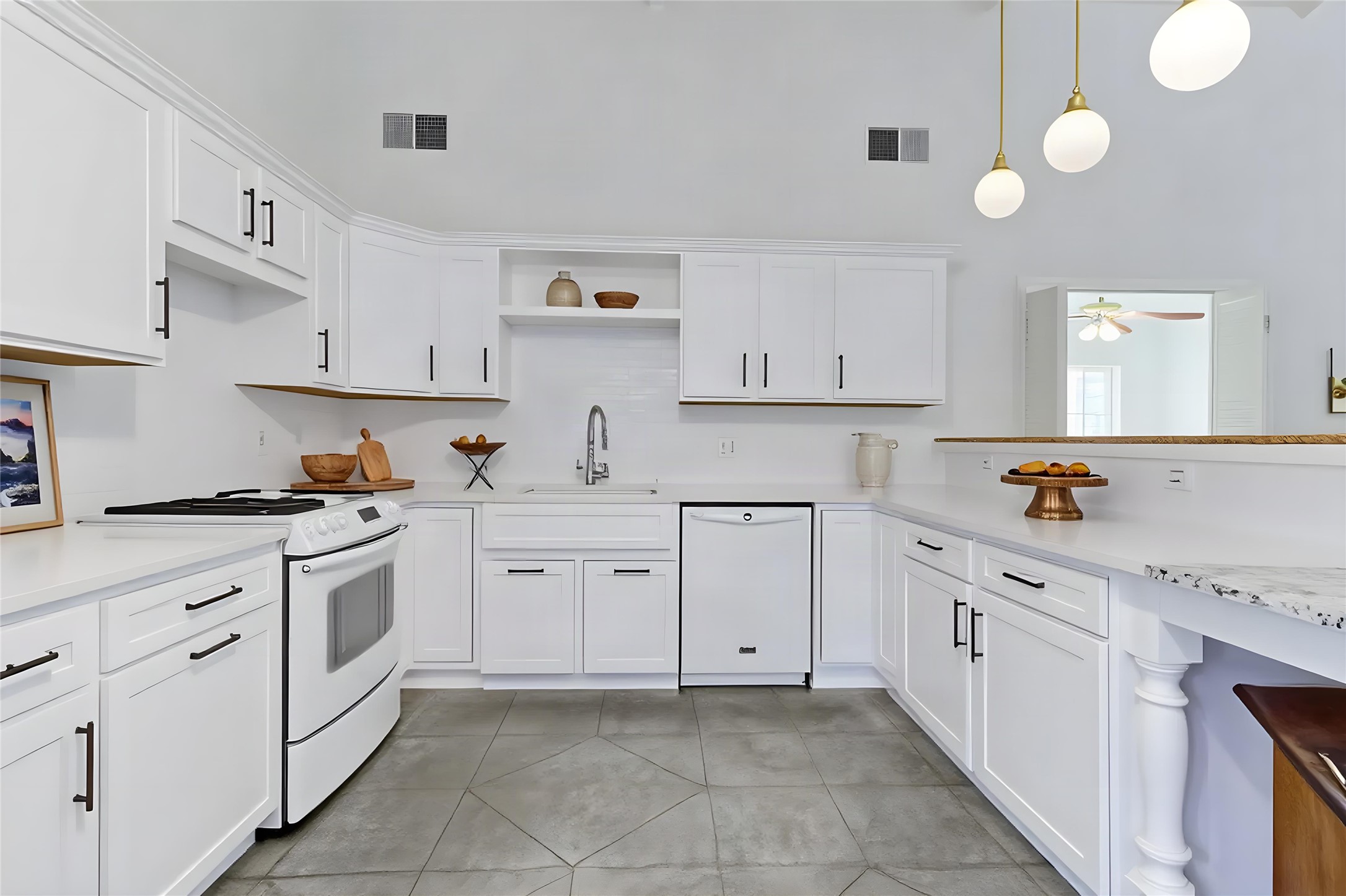 2084 Upper Elgin River Road Elgin, TX 78621 - Photo 1 of 1 High vaulted ceilings and stone-patterned tile flooring frame this classic white kitchen workspace.