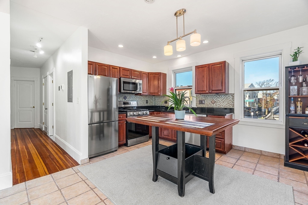 372 Adams Street, Unit 2 Boston, MA 02122 - Photo 12 of 20 a kitchen with stainless steel appliances granite countertop a refrigerator and a stove top oven