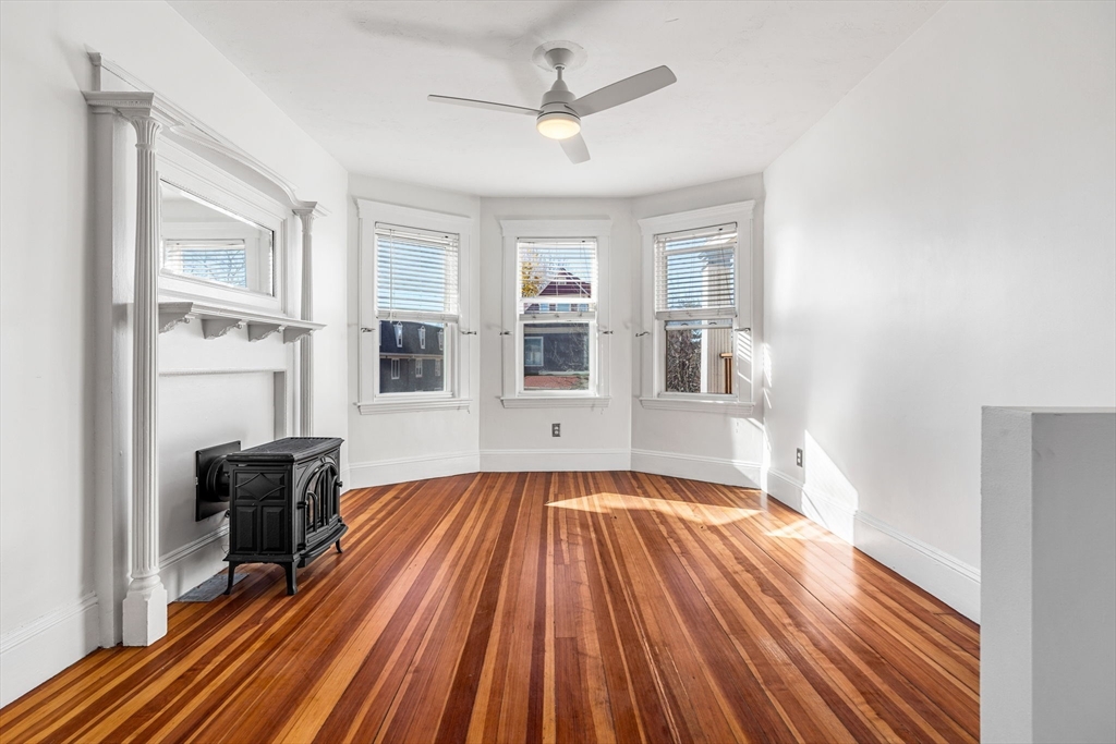 372 Adams Street, Unit 2 Boston, MA 02122 - Photo 3 of 20 a view of a livingroom with wooden floor and a ceiling fan