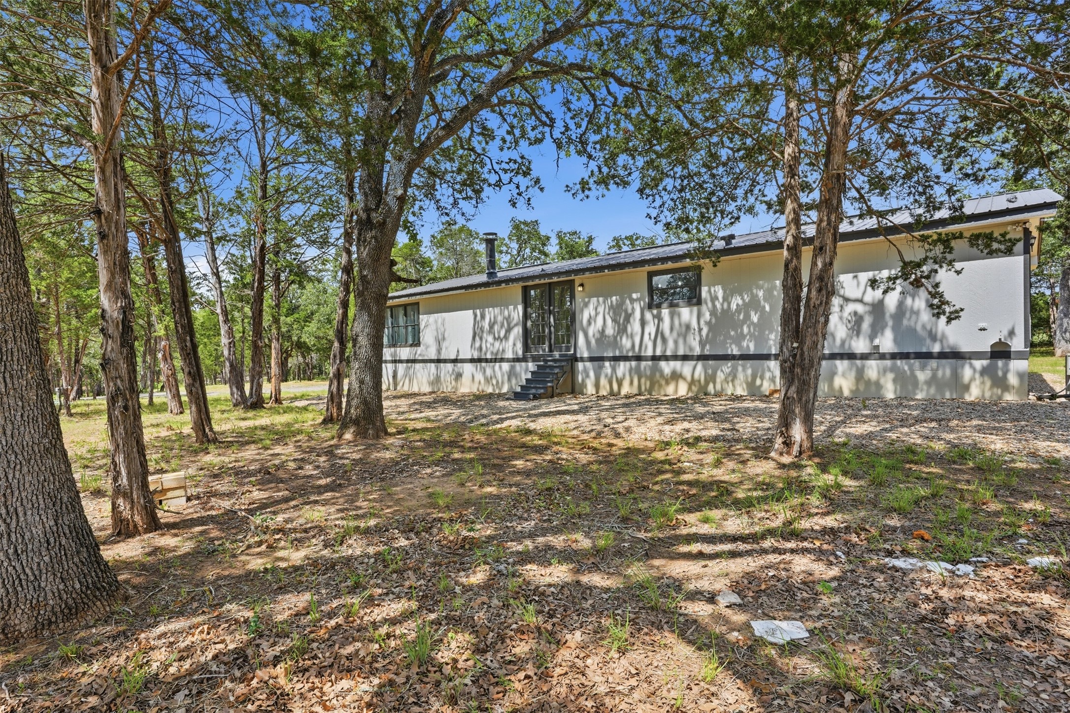 154 Antioch Road Smithville, TX 78957 - Photo 25 of 32 A tranquil wood-lined setting surrounds this inviting single-story residence, offering peaceful seclusion.