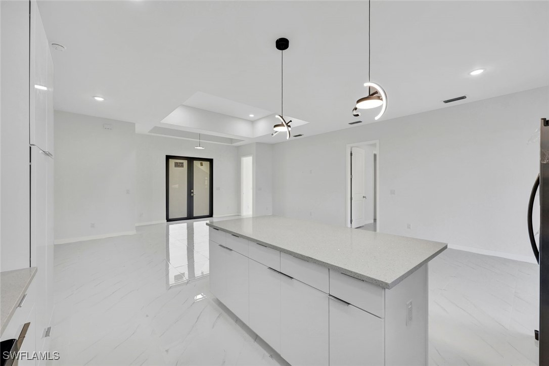 347 Ranch Avenue Lehigh Acres, FL 33974 - Photo 12 of 30 a kitchen with a refrigerator a sink and chandelier