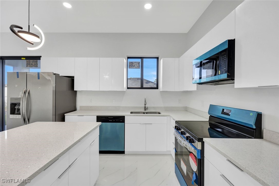 347 Ranch Avenue Lehigh Acres, FL 33974 - Photo 13 of 30 a kitchen with a stove a sink and a refrigerator