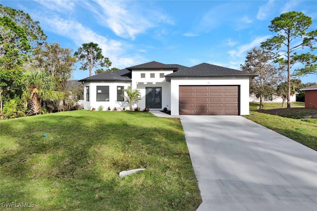 347 Ranch Avenue Lehigh Acres, FL 33974 - Photo 2 of 30 a front view of a house with a yard and garage