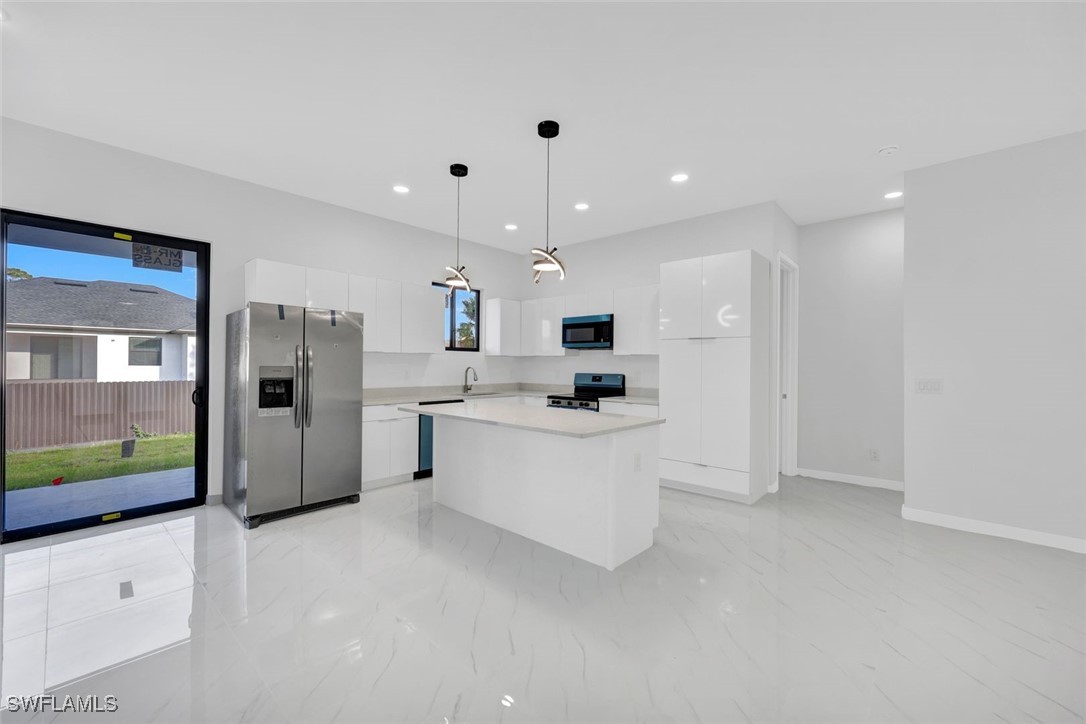 347 Ranch Avenue Lehigh Acres, FL 33974 - Photo 10 of 30 a large white kitchen with refrigerator stove microwave and sink
