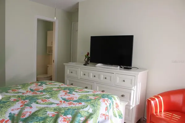 a bedroom with a bed and flat screen tv