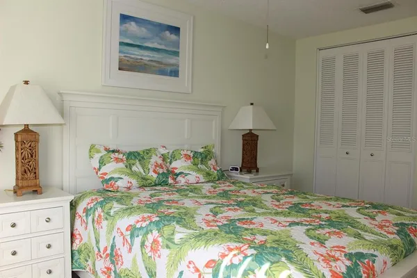 a bedroom with a bed and a lamp on dresser