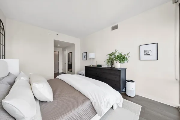 a bedroom with a bed and painting on the wall