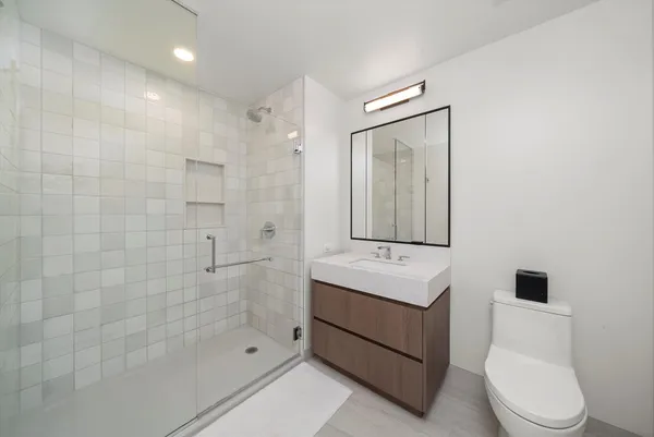 a bathroom with a sink a toilet and shower