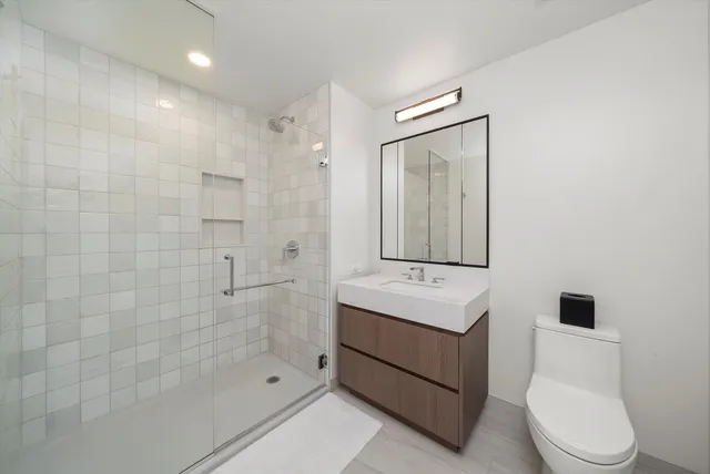 a bathroom with a sink a toilet and shower