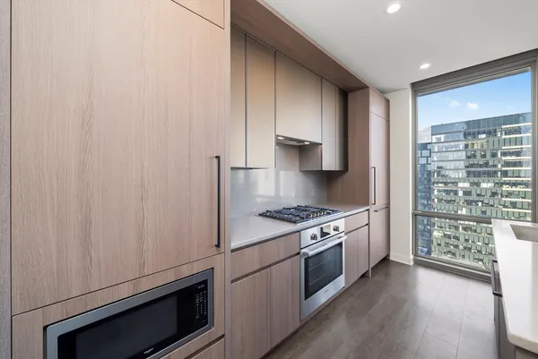 a kitchen with granite countertop cabinets stainless steel appliances and wooden floor
