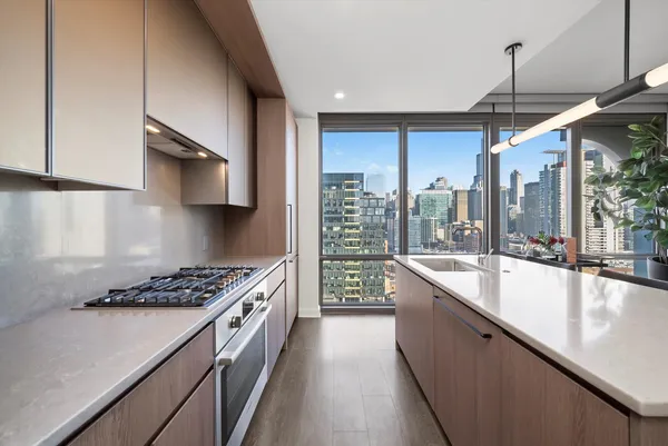 a kitchen with stainless steel appliances a sink a stove and a wooden floors