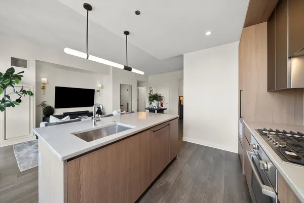 a large kitchen with kitchen island a sink stainless steel appliances and cabinets