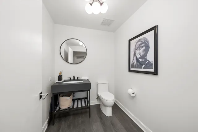 a bathroom with a toilet a sink and mirror
