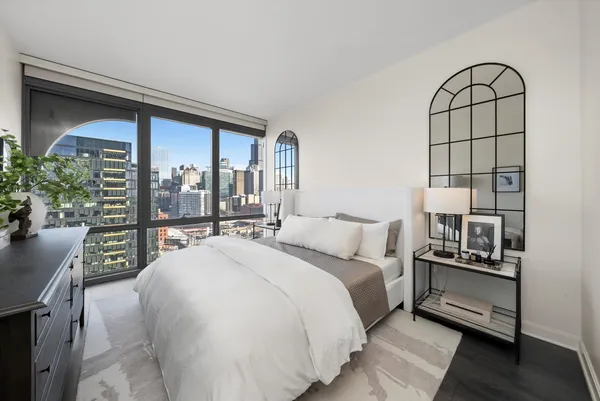 a bedroom with a large bed and a chandelier