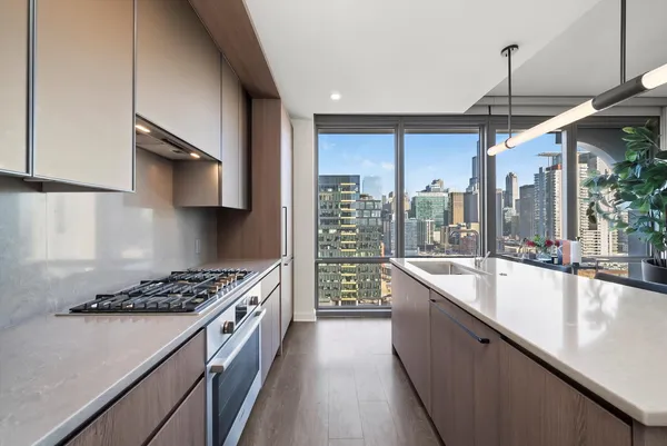a kitchen with stainless steel appliances a sink a stove and a wooden floors