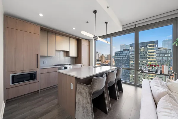 a kitchen with a sink a counter top space stainless steel appliances and a large window