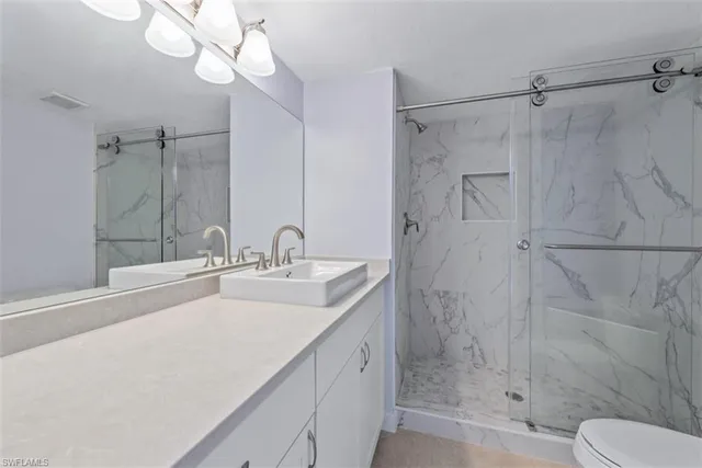 a bathroom with a double vanity sink mirror and shower