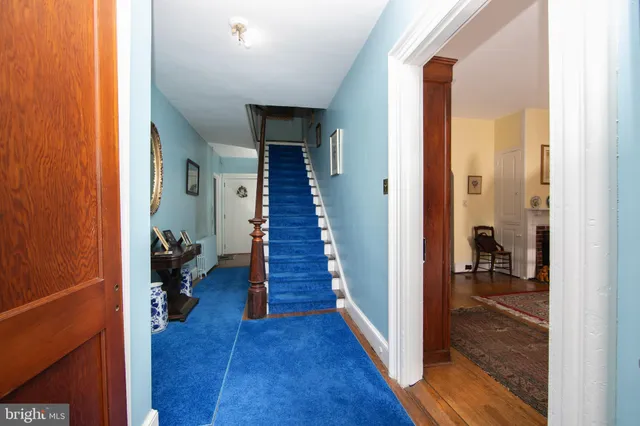a view of a hallway with wooden floor and a livingroom