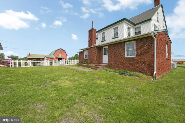 a view of a house with a yard and a street