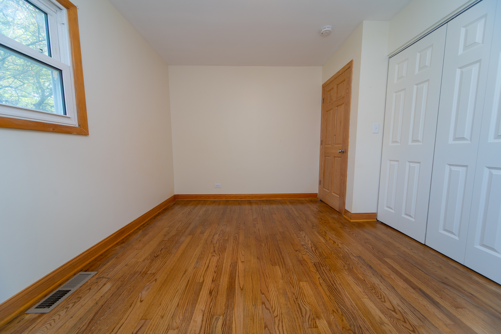 543 Rose Avenue Addison, IL 60101 - Photo 8 of 18 a view of an empty room with wooden floor and a window