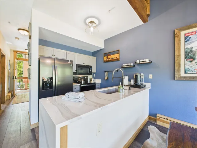 a kitchen with stainless steel appliances kitchen island a refrigerator sink and stove