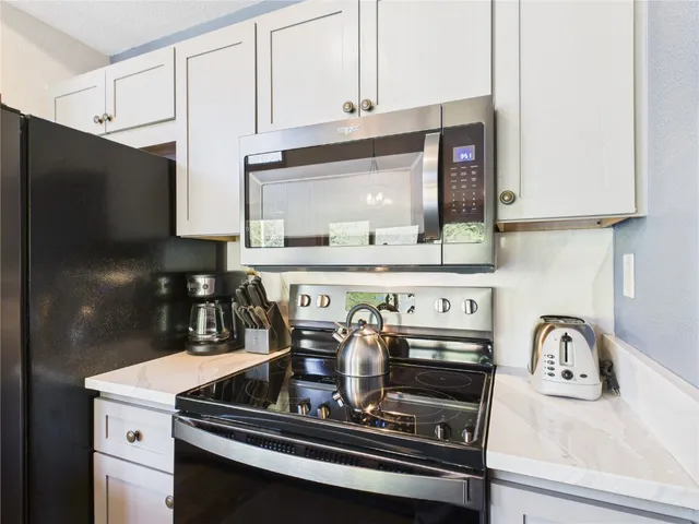 a kitchen with stainless steel appliances granite countertop a sink a stove and a refrigerator