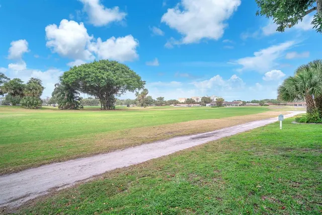 a kitchen with stainless steel appliances granite countertop a stove a microwave a sink a dining table and chairs with wooden floor