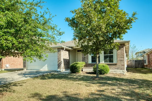 a view of a house with a yard and large tree