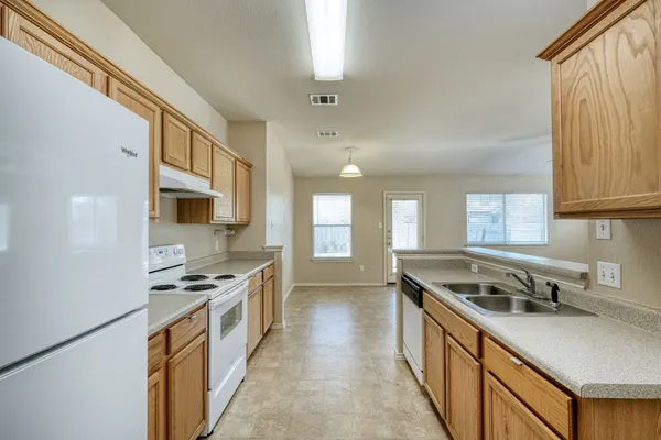 an empty room with a kitchen and a sink