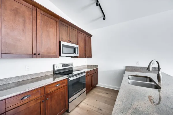 a kitchen with stainless steel appliances granite countertop a sink stove and microwave