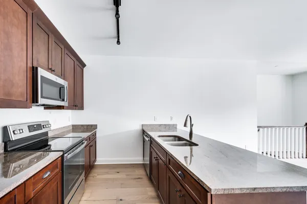 a kitchen with stainless steel appliances a sink dishwasher stove refrigerator and microwave