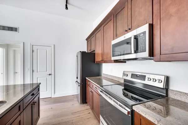 a kitchen with stainless steel appliances a stove a microwave a sink and cabinets