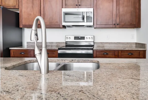 a kitchen with granite countertop a stove and a sink with granite countertops