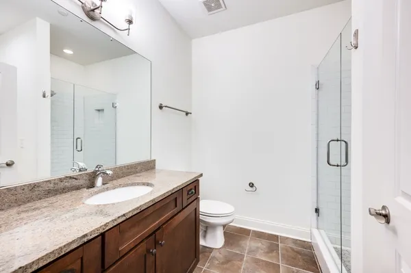 a bathroom with a granite countertop sink toilet and shower