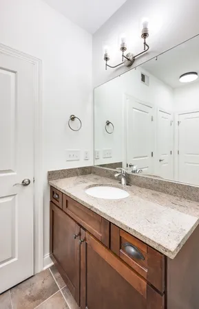 a bathroom with a granite countertop sink and a mirror