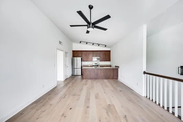 a view of a kitchen with a sink and dishwasher a refrigerator with wooden floor