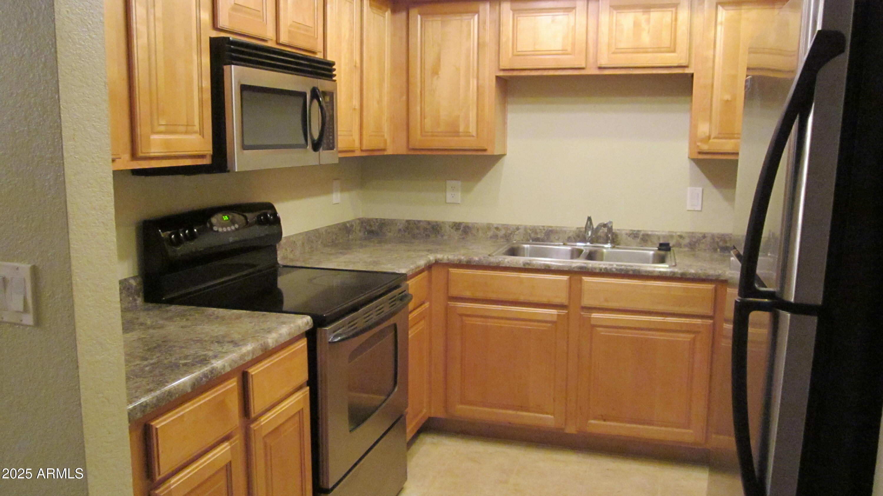 1340 North Recker Road, Unit 323 Mesa, AZ 85205 - Photo 8 of 13 a kitchen with a sink stove and refrigerator