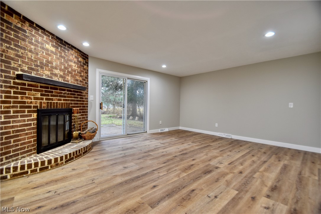 7520 Johnnycake Ridge Road Mentor, OH 44060 - Photo 21 of 36 Unfurnished living room featuring a brick fireplace and light wood-type flooring