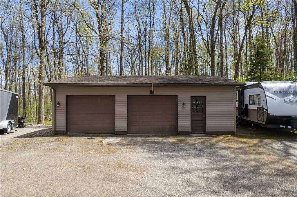 255 Claytonia Road Butler, PA 16001 - Photo 7 of 50 Expansive 32x24 detached garage with two-car capacity and a separate man door—perfect for vehicles, storage, or creating a dedicated workspace or hobby area.