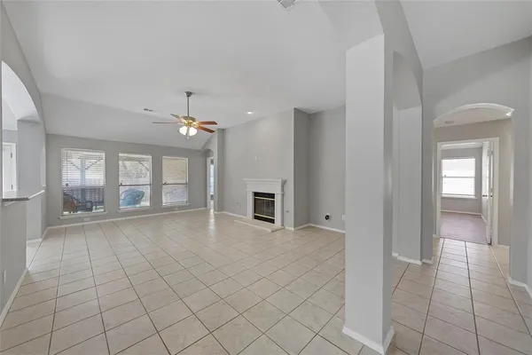 a view of a livingroom with a chandelier fan and windows