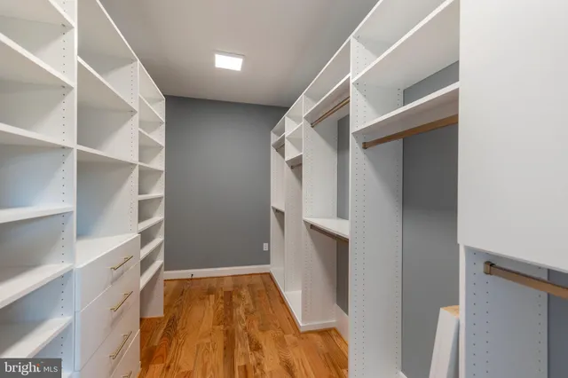 a view of walk in closet with empty racks