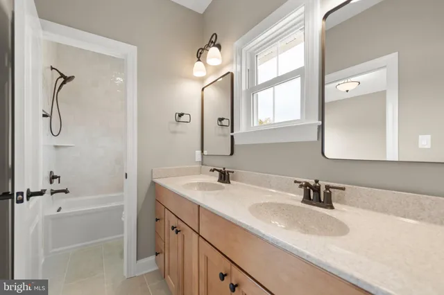a bathroom with a granite countertop sink mirror and a bathtub