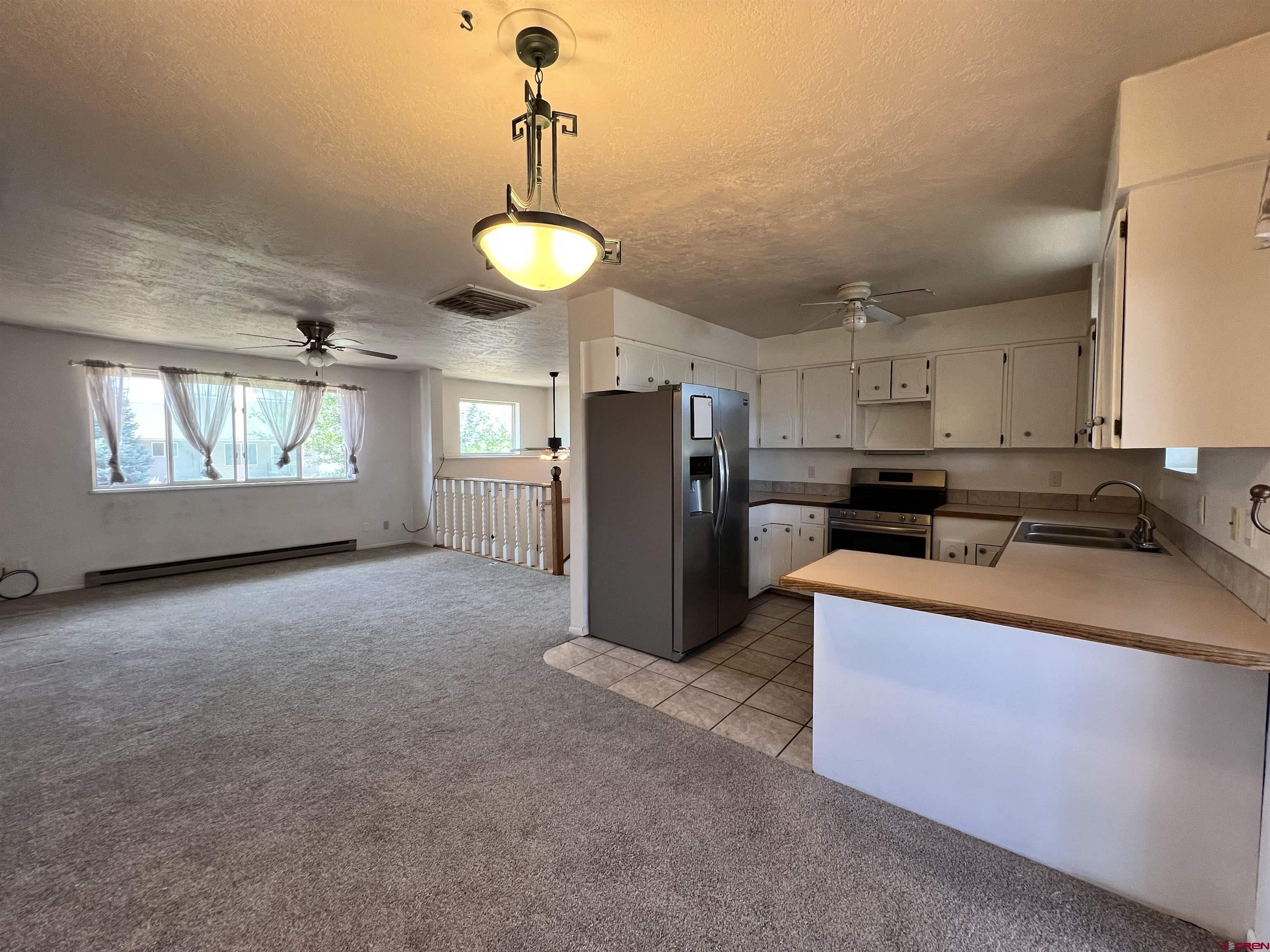1328 Jackson Street Cortez, CO 81321 - Photo 7 of 37 a view of a kitchen with a sink and dishwasher a refrigerator with wooden floor