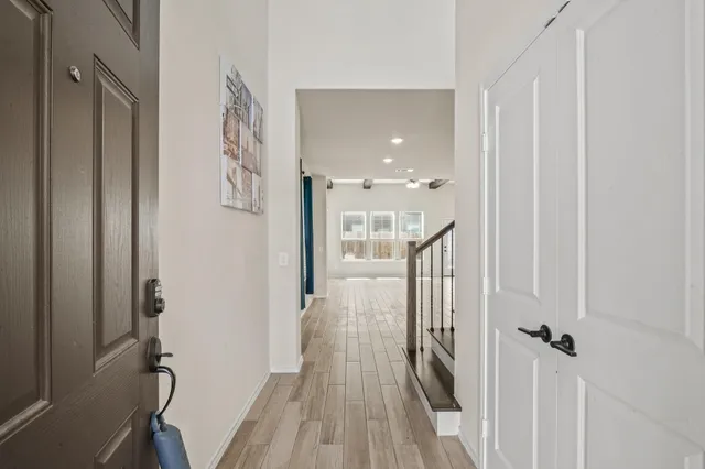 a view of a hallway with wooden floor and staircase