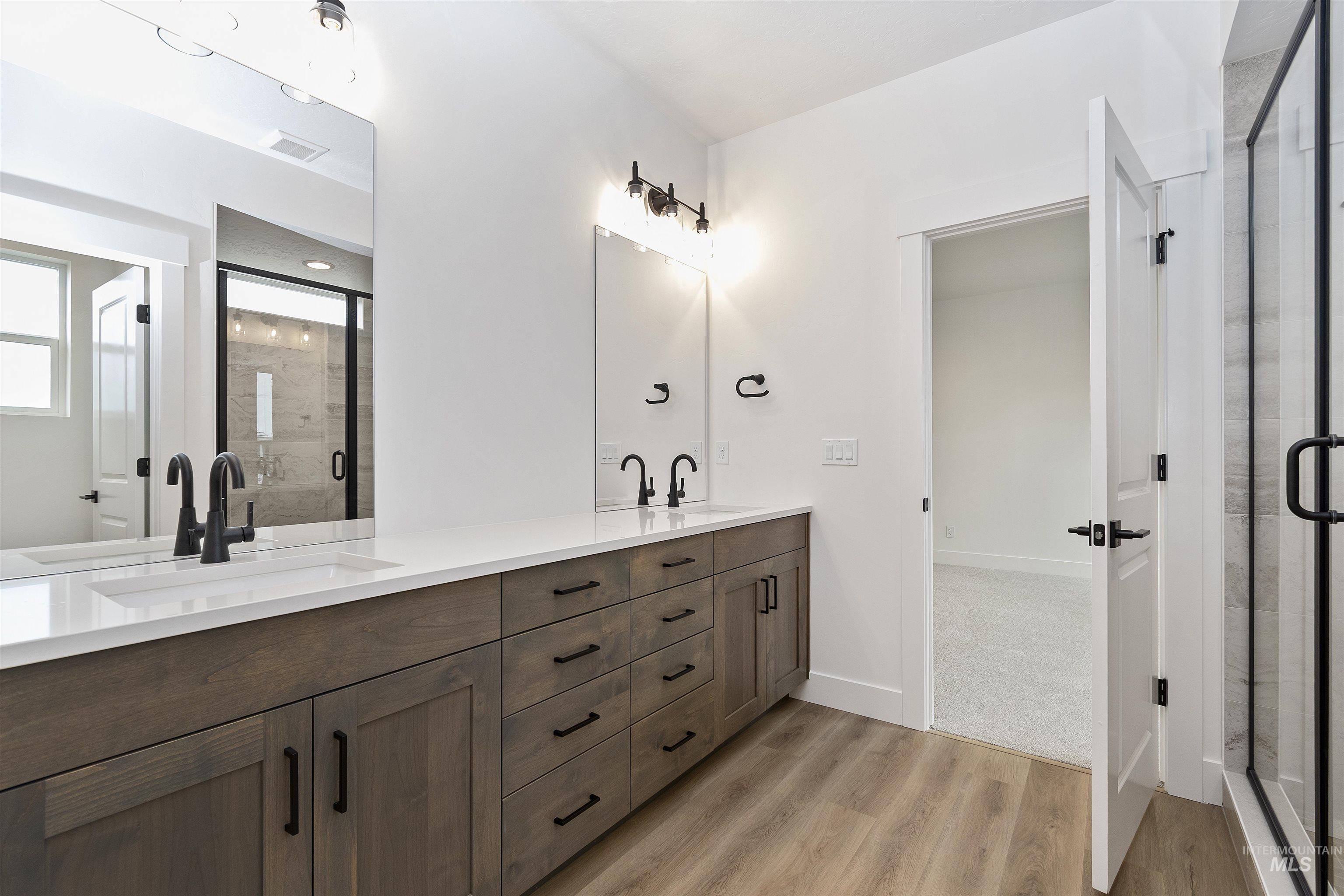 732 South Calhoun Lane Star, ID 83669 - Photo 21 of 48 Full bath with double vanity, light wood-style flooring, and a shower stall