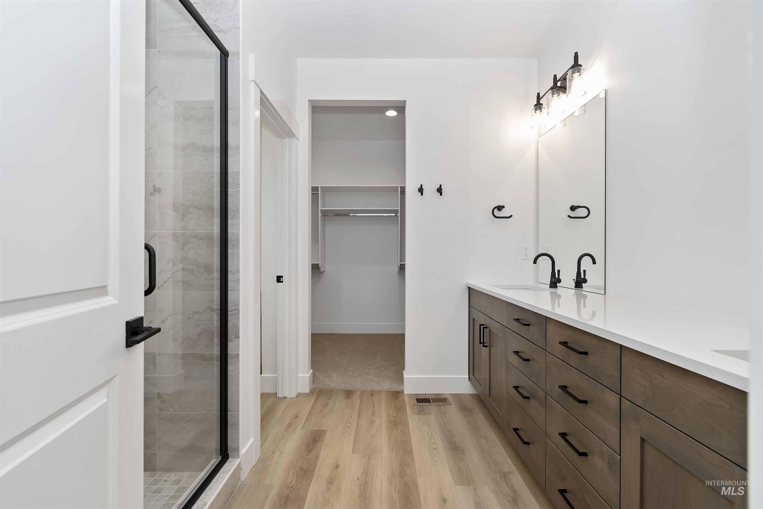 732 South Calhoun Lane Star, ID 83669 - Photo 24 of 50 Full bath with a walk in closet, double vanity, light wood finished floors, and a stall shower