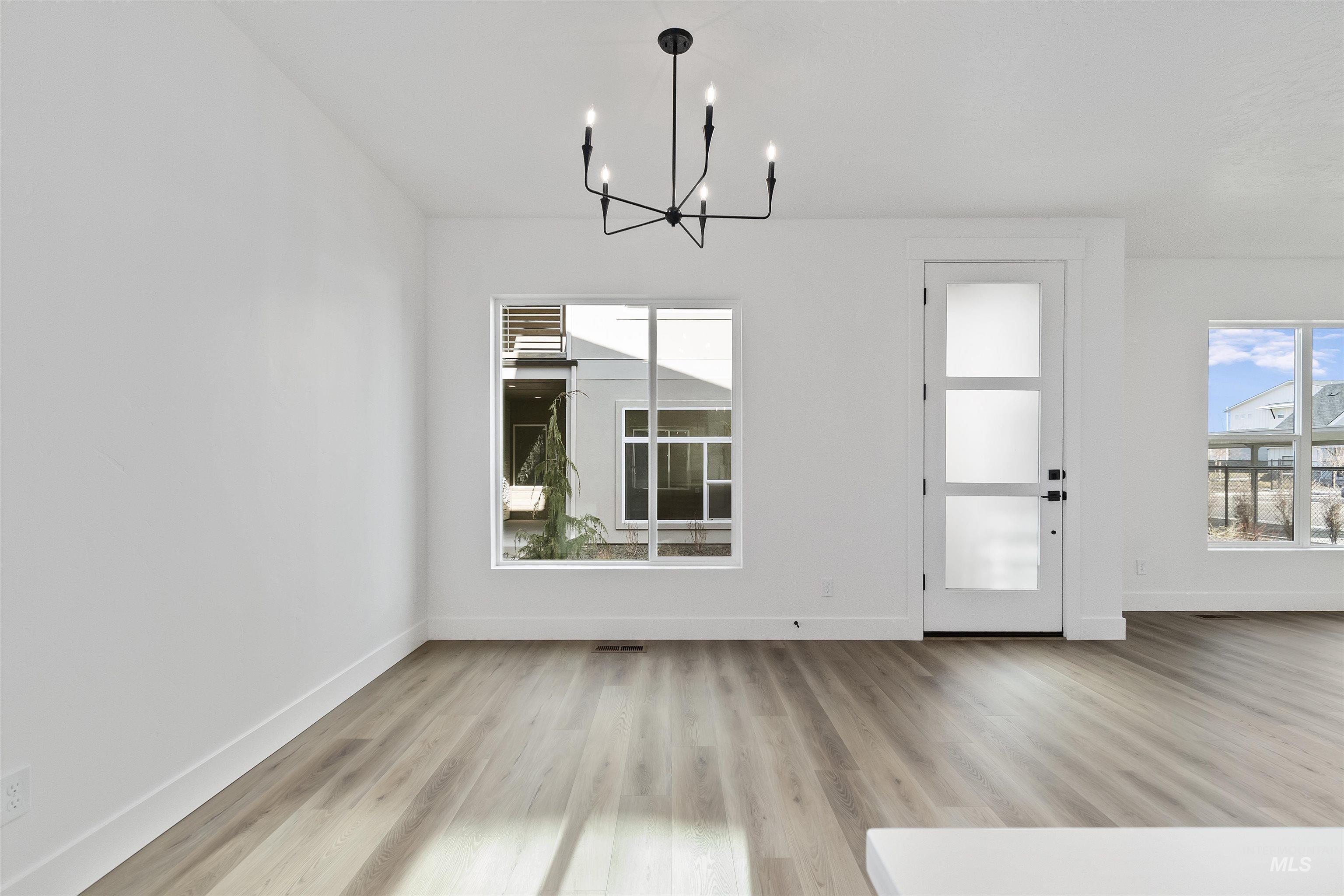 732 South Calhoun Lane Star, ID 83669 - Photo 5 of 48 Unfurnished dining area featuring healthy amount of natural light, light wood-style floors, and a chandelier