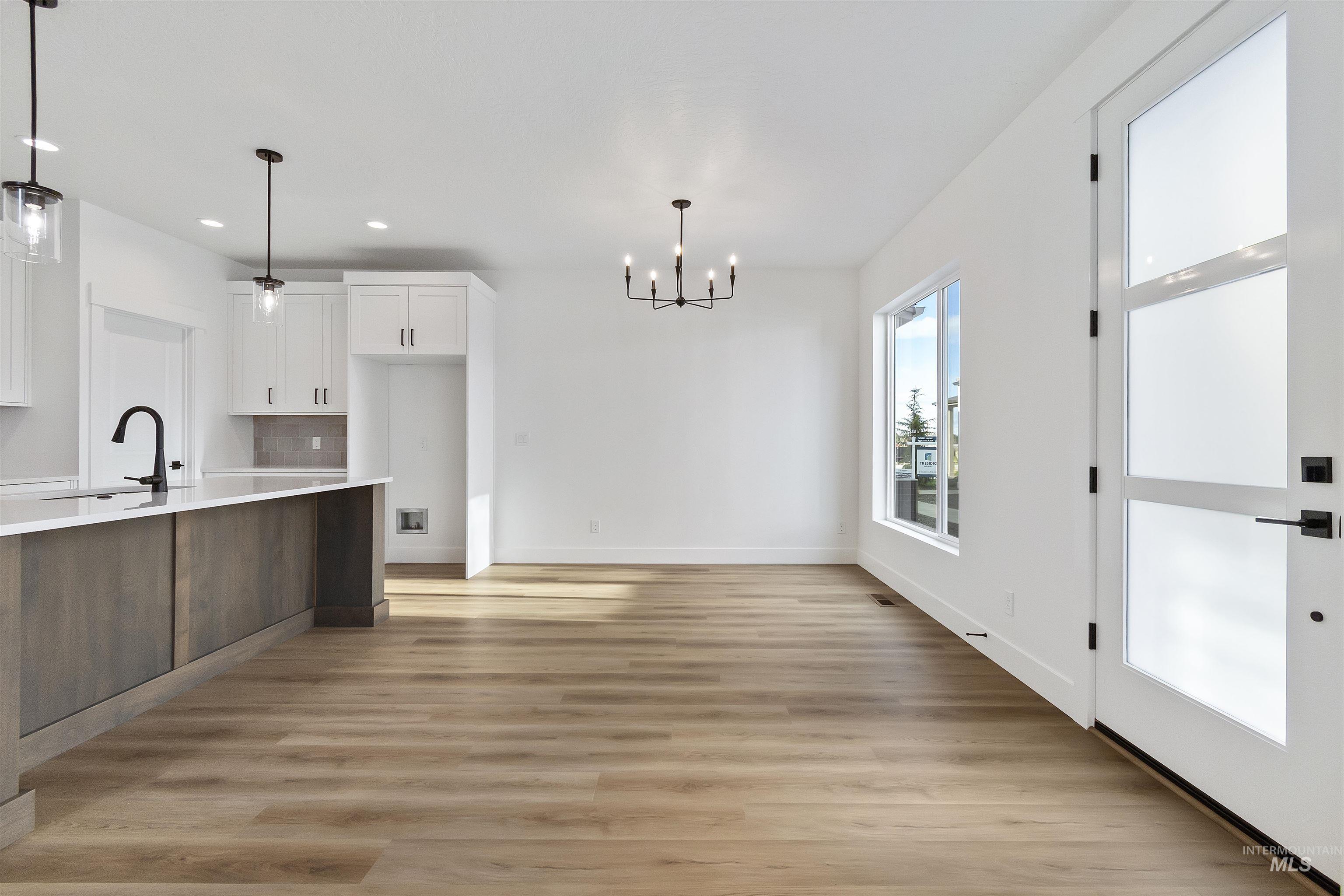 732 South Calhoun Lane Star, ID 83669 - Photo 6 of 50 Kitchen featuring white cabinets, a chandelier, light wood-style floors, recessed lighting, and brown cabinets